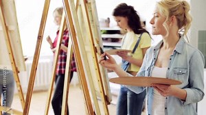 students with easels painting at art school