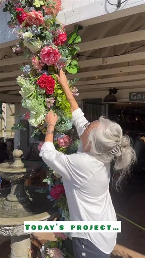 One galvanized garbage can, one metal funnel, some pipe, paint and a whole bunch of flowers to feed our Spring fever! I could not have thought of a better project for a 70 degree and sunny February day! Let us know if you have any questions…always happy to help if we can. #springfever #shop901 #901memphis #springdecor #fauxflowers | Millstone Market & Nursery