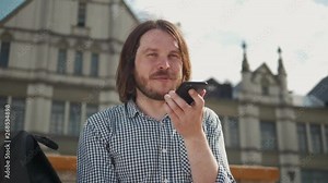 Man using the voice recognition on the phone, audio message ai speech helper, student male outdoor