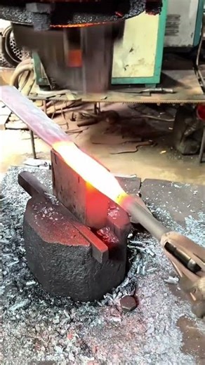 forging glowing hot metal on an anvil with an industrial power hammer for traditional blacksmith