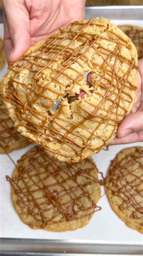 4.6K views · 52 reactions | Introducing our new Caramel COOKIES!  These cookies are loaded with mini caramel cups, chewy caramel pieces, toffee, and drizzled with caramel ganache! 勞 They’re insanely delicious and available today and tomorrow at both locations!! 癩#designerdessertsbakery #livelifeonecupcakeatatime #lifeofabaker #bakery #cookies #bakewithme #cookie #caramel #caramelcookies | Designer Desserts-Valparaiso | Facebook