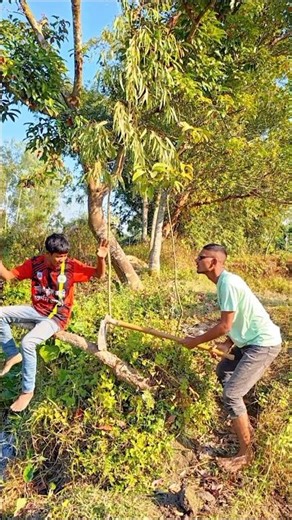 The boy was sitting on a tree and digging with a spade