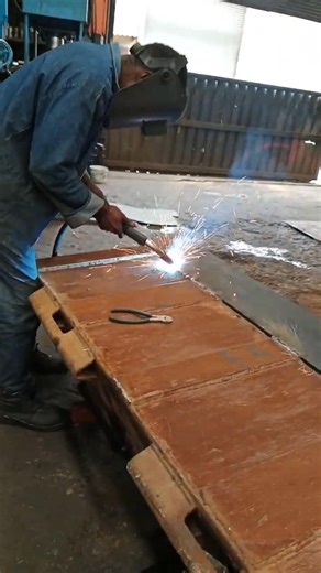 GAS METAL ARC WELDING PROCESS DURING CATERPILLAR BUCKET REPAIR IN MANUFACTURING WORKSHOP BY EXPERT