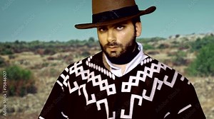 Footage of a gunslinger looking at camera while smoking a cigar.