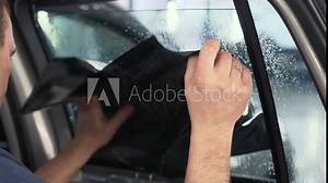 Car window tinting. Process of Installation window tint in Car Detailing Studio Garage by professional detailer.