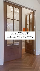 This stunning walk-in closet, accessed through custom wood French doors right off the luxurious ensuite, is a blend of elegance and functionality. Featuring ample hanging space, built-in shelving, drawers, and a cozy seating bench under vaulted ceilings, it’s a space designed for both storage and style. #closet #closetgoals #dreamhome #housegoals #instahome | Veranda Estate Homes Inc.