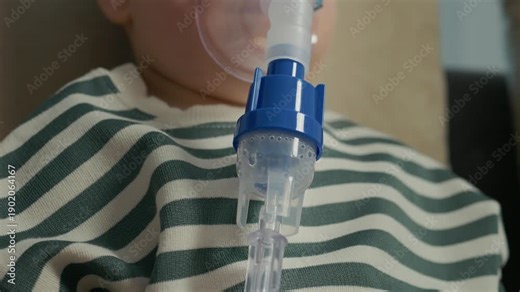 A child uses a nebulizer with a mask that releases steam to treat coughs and respiratory infections. The saline solution helps with breathing difficulties.