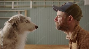 Seated man with cap intense stare off with blue-eyed husky collie dog, profile