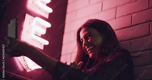 Selfie, air kiss and woman in city at night, happiness and call me sign of influencer. Kissing blow, female person and taking photo for shaka emoji, social media or funny profile picture with neon.