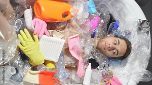 Man drowning under plastic recipients pile, garbage, used packs filling world ocean killing people. ecology, environment concept, plastic and glass pollution, nature disaster pollution