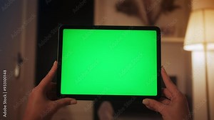 Girl with green screen display. Hands hold horizontal tablet close up. Person watching video or movie using digital tablet.