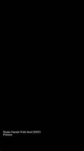 This Ran on MTV in ’97. People Had No Clue What They Were Watching. “Shake Hands With Beef” was released as the lead single from Primus’ Brown Album in 1997. It was the band’s first major release with new drummer Bryan “Brain” Mantia, after Tim Alexander’s departure. The song features Les Claypool’s signature slap bass and an intentionally disjointed rhythm section. The music video was directed by Claypool himself and aired regularly on MTV. It showed the band performing in a residential drivewa