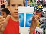 Young magician performs floating cup trick in a supermarket