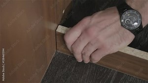 young man fastens one board to another by means of bolts. close-up