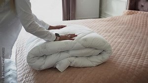 Service staff girl cleans the hotel room and bring new bedding