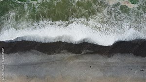 Drone 4k footage of a rocky beach in Lima, Peru. It's a topdown shot of waves crashing on shore.
