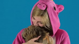 Une adolescente en pyjama de licorne embrasse un joli chih Tzu sur fond bleu. Une fille joyeuse aime le moment avec un adorable animal de compagnie