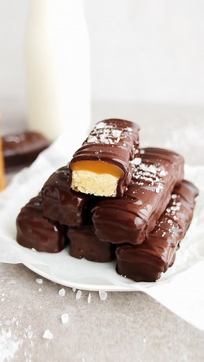 VEGAN TWIX BARS🍯🍫 YAY or NAY?? Who wants one? Vegan TWIX Bars DIY! Soft & buttery shortbread, chewy caramel coated in chocolate! They taste IDENTICAL to classic TWIX Bars but BETTER as they’re vegan, egg-free, dairy-free, 7 simple ingredients! Perfect candy bar for Halloween & the festive season! 🎃🍫 What you’ll need: 🍫All purpose / plain flour 🍯Caster sugar 🍫Dairy-free butter 🍯Vanilla extract 🍫Light brown sugar 🍯Vegan condensed milk 🍫Dairy-free chocolate . Get the recipe: Click the li