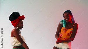 Two young black women dancing freely to a steady beat.