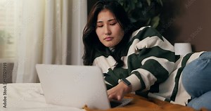 Laptop problems. A woman lies on the bed and works remotely on the computer. Girl gets angry because hardware crashed virus hacked system, error, deleted documents.