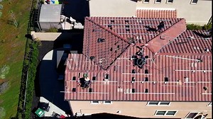 Installing the framework for solar panels on the roof of a home - aerial sliding view