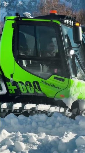 Extreme snow groomers carving perfect ski slopes in deep winter mountain resorts.