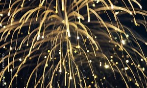 Golden Fireworks Cascade: A mesmerizing spectacle of golden fireworks explodes against a dark night sky, creating a cascade of shimmering light trails. The image captures the beauty and wonder of pyro