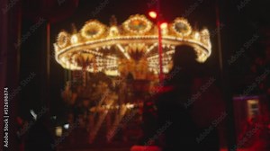 Illuminated Merry Go Round Carousel Rotating in an Amusement Park at Night
