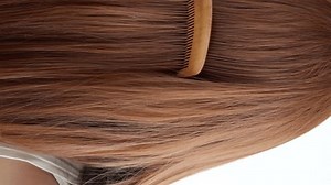 Closeup on a young woman combing her hair