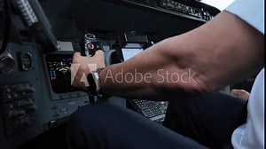 Close-up view inside a jet cockpit while having extreme turbulence in a real time flight. European Captain piloting the airplane. Low angle view. 4K 60FPS