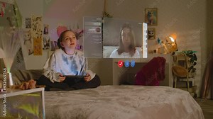 Teenager girl uses tablet computer, talks to friend in AR chat app using virtual reality, sits on bed at home. VFX graphics of holographic video call interface. Futuristic metaverse. Augmented reality