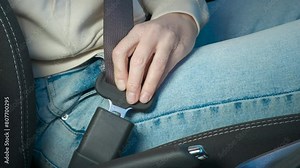 Woman fix belt in car cabin. A female hand fix her seat belt in the car cabin before driving.