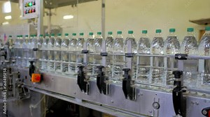 Automatic conveyor line for bottling mineral water in the plastic bottle. Line for PET bottle water. Water factory-bottling pure spring water into bottles. Selective focus.