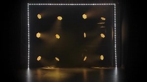 Stage light rays in an empty concert hall. Professional lighting and show effects. Yellow dynamic spotlights and spot white lighting shine against a black background.