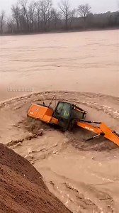 Ohio Flooding Sweeps Away Excavator in Harrowing Footage! Dayton, Ohio – March 12, 2025 A terrifying incident unfolded today along the Great Miami River as extreme flooding caused an excavator to plunge into the raging waters. Local residents, witnessing the rapid erosion of the riverbank, captured the harrowing event on video. The footage shows a large orange excavator perched precariously on the muddy edge of the swollen river. A construction worker, wearing a high-visibility vest, is seen ins