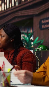 Vertical Video Cast members practicing script reading for a classic drama play in a library, showing dedication to acting and passion for character development. Theatrical arts role play. Camera B.