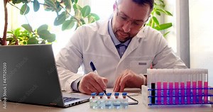 Work in a modern clinic - doctor processes patient data and makes notes in the journal.