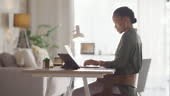A young business woman working remote at home with a laptop in an...