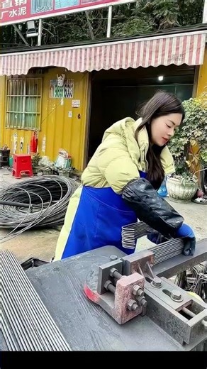 Woman skillfully operates metal forming machine