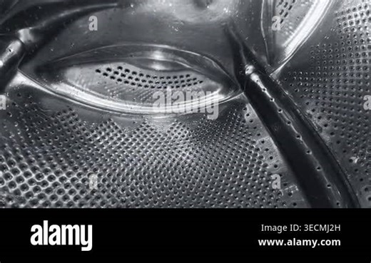 Creative wide-angle view from inside a spinning washing machine drum. Water streams down the metallic surface during a wash cycle. Industrial and domestic cleaning concept Stock Video Footage - Alamy