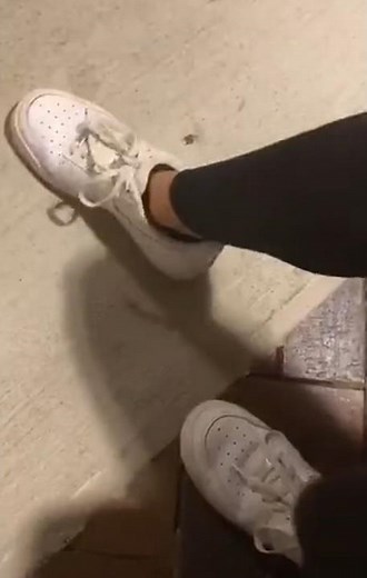 candid young woman next to me squashes bug in Nike sneakers