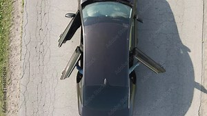 Three doors of a passenger car open wide, top view. Bird's-eye view of a vehicle standing on an asphalt road. Warm, clear, summer day. The concept of embarking on a trip, journey. UHD 4K.