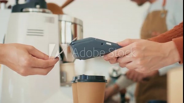 Close up of Customer hand using credit card tapping on Card Reader, terminal for making payment in coffee shop. Cashless and Contactless payment buying drink, making payment transaction to cashier. 素材庫影片