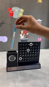 1.6K views | Infinity Calendar Penstand Scope of name customised on the silver name plate  Material: Black MDF material 3 white rings for Day, date & month Attached with a small table clock Pen Organiser aswell Any Name , Brand Name Can Be Customised. Watsapp on 9711933174 for price and Placing Orders. | Gift Emporio | Facebook