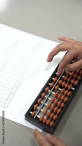 little kid solving math problems using mental arithmetic and paper in school classroom.
