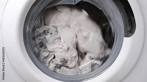 Washing clothes in a washing machine. Slow motion.