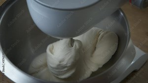 Dough in a food processor. A home processor is kneading the dough.