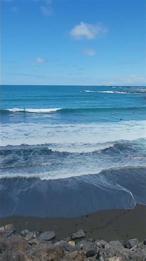 sound of waves at the beach with surfers in the background