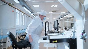 A Worker is testing the quality of the medical surgical lights. Using a computer for Performing a Test on a produced medical lights. Medical lights Testing Process at the factory. Medical Equipment.