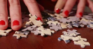 Young Woman Solving A Jigsaw Puzzle
